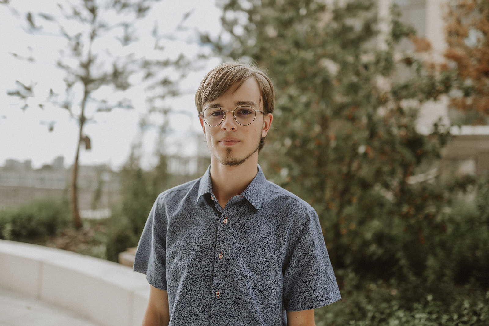 Photo personnelle dans une chemise bleue avec un décor végétal